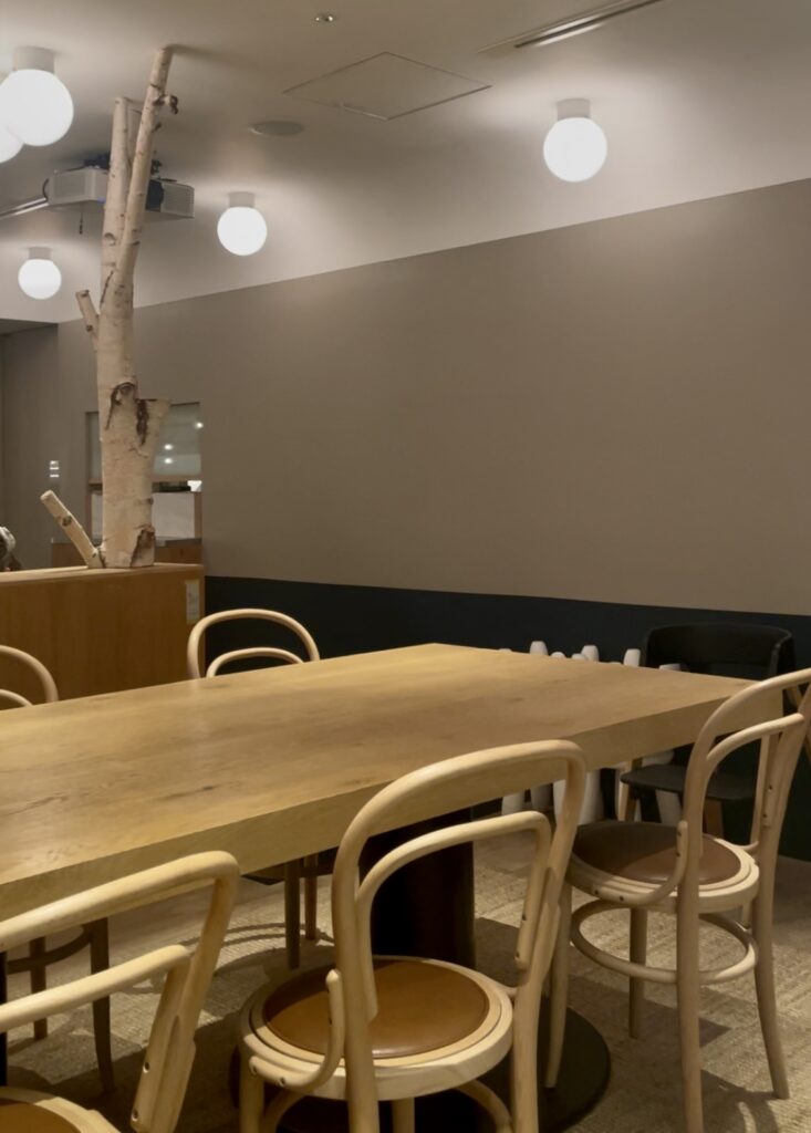 木のテーブル席と丸い照明が灯る店内